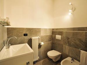 uma casa de banho com um lavatório branco e um WC. em Mansarda Di Pianello em Pianello Del Lario