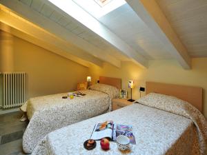 Pianello Del LarioにあるMansarda Di Pianelloのベッドルーム1室(ベッド2台、天窓付)