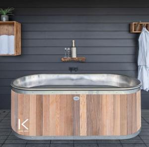 y baño con bañera de madera y lavamanos. en Kamana Lakehouse en Queenstown