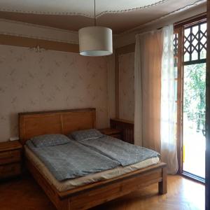 a bedroom with a bed and a large window at Hotel Villa Borjomi in Borjomi +41 photos