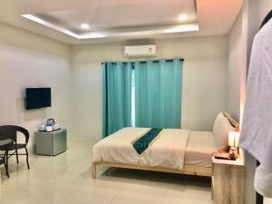 1 dormitorio con cama y cortina azul en Emma en Ban Pak Khlong Phe