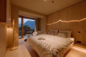 a bedroom with a large bed and a large window at Hotel Bohinj in Bohinj