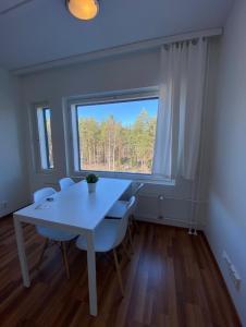 una mesa y sillas blancas en una habitación con ventana en Kotimaailma - Saunallinen kolmio lähellä lentokenttää, en Vantaa