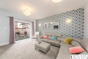 a living room with a couch and a mirror at Loveliest Homes Paignton - Casa Marina - 3 bed, 2 bathroom house, balcony, parking in Paignton