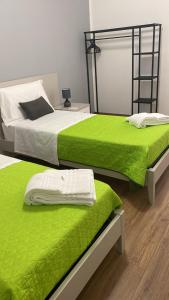 two beds with lime green covers in a room at M&G holiday house in Matera