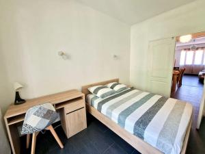 a bedroom with a bed and a desk and a chair at Appartement cosy : 3 chambres in Marseille