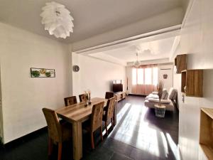 a living room with a wooden table and chairs at Appartement cosy : 3 chambres in Marseille