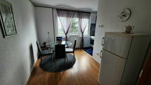 a kitchen and dining room with a table and a refrigerator at Apartman Bella in Sarajevo