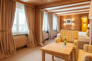 a hotel room with a couch and a bed and a table at Sonnenalp Resort in Ofterschwang