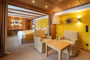 Habitación de hotel con cama, mesa y sillas en Sonnenalp Resort en Ofterschwang