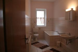 a bathroom with a sink and a toilet and a window at Landgasthof Hotel Rebe Alzey in Alzey