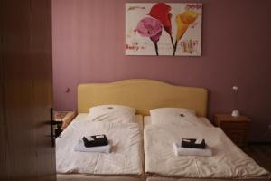アルツァイにあるLandgasthof Hotel Rebe Alzeyのベッドルーム1室(ベッド2台付)が備わります。壁には絵画が飾られています。