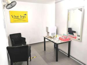 a dressing room with a table and a mirror at Vive Inn in Kuah