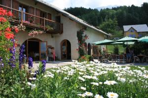 a building with a garden with flowers and umbrellas at Les Alisiers in Montclar