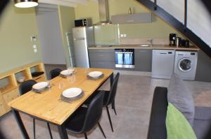 a kitchen with a wooden table and chairs in a kitchen at Le Clos des Taulelles gîte Le Figuier in Saint-Privat-de-Champclos +10 photos
