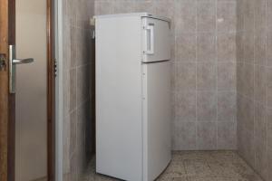 einen weißen Kühlschrank in einer Ecke eines Zimmers in der Unterkunft Estirpe, 3º-6 in Cullera