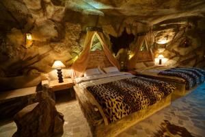 ein Schlafzimmer mit einem Leopardenbett in einer Höhle in der Unterkunft Caves Beach Resort Adults Only in Hurghada