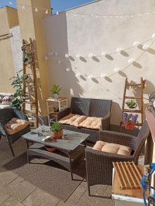 un patio con 2 sillas de mimbre y una mesa en Acogedor Apartamento Ocaña, en Ocaña