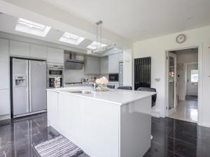 a kitchen with a white island in a room at Pass the Keys Spacious 3 Bed by River Thames Old Windsor in Windsor
