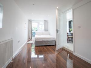 a white room with a bed and a window at Pass the Keys Spacious 3 Bed by River Thames Old Windsor in Windsor