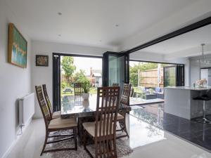 a dining room with a glass table and chairs at Gorgeous Family Home Near River Thames-Old Windsor - Pass the Keys in Windsor +15 photos