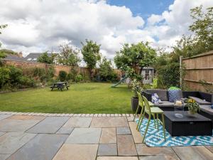 a patio with a table and chairs in a yard at Pass the Keys Spacious 3 Bed by River Thames Old Windsor in Windsor