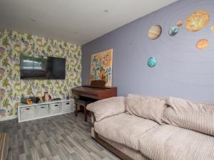 a living room with a couch and planets on the wall at Pass the Keys Spacious 3 Bed by River Thames Old Windsor in Windsor