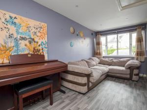 a living room with a couch and a piano at Gorgeous Family Home Near River Thames-Old Windsor - Pass the Keys in Windsor