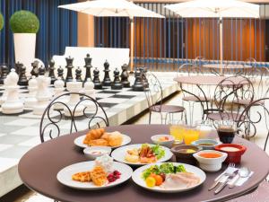 a table with plates of food on top of a chessboard at Hotel Villa Fontaine Kobe Sannomiya in Kobe