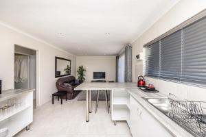 cocina con mesa y escritorio en Southeaster, en Bloubergstrand