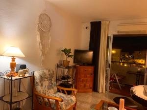 a living room with a chair and a television at Ferienwohnung in Vélez-Málaga, Málaga in Málaga