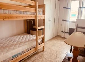 a bunk bed room with two bunk beds and a desk at Ferienwohnung in Vélez-Málaga, Málaga in Málaga