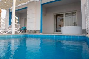 a villa with a swimming pool and a house at Casa Blue Resort in Marsa Alam City