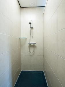 y baño con ducha y alfombra negra. en Vakantiewoningen Ut Tumpke, en Kessel