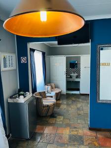 een woonkamer met 2 stoelen en een groot oranje plafond bij Kate's Nest Guesthouse in Windhoek