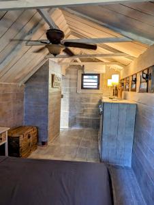 Habitación grande con ventilador de techo y mesa. en Chalet De Tahiti, en Punaauia