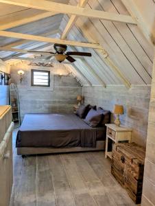 una camera con letto e ventilatore a soffitto di Chalet De Tahiti a Punaauia
