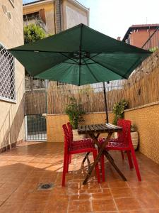 ローマにある40metri d’amorのテーブルと椅子2脚(緑の傘付)