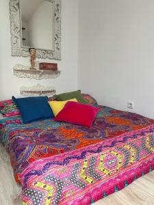 a bed with colorful pillows on it in a room at Casa Vacacional La Coruña in Culleredo