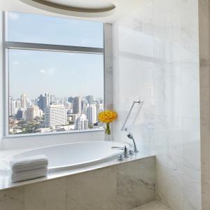 a bathroom with a white tub and a window at Bangkok Marriott Hotel Sukhumvit in Bangkok