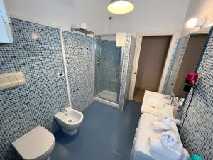 Un baño con azulejos azules, inodoro y lavabo. en Casa Emma, en Pescara