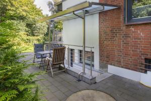 a patio with a table and a building at Neue zentrale Souterrain-Wohnung 24h Self Check-In in Hamburg