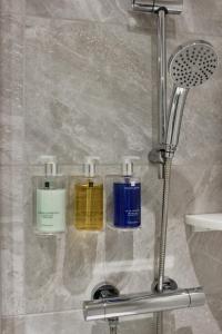 three bottles ofodorizers on a glass shelf in a shower at Lincombe Hall Hotel & Spa - Just for Adults in Torquay