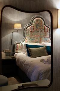 lustro odzwierciedlające sypialnię z łóżkiem z zagłówkiem w obiekcie Lincombe Hall Hotel & Spa - Just for Adults w mieście Torquay