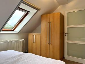 ein Schlafzimmer mit einem Holzschrank und einem Fenster in der Unterkunft Apartmán Štěpán in Velké Karlovice