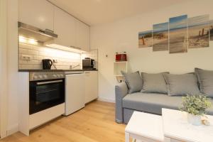 a living room with a couch and a kitchen at Neue zentrale Souterrain-Wohnung 24h Self Check-In in Hamburg
