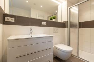 a bathroom with a toilet and a sink and a shower at Neue zentrale Souterrain-Wohnung 24h Self Check-In in Hamburg