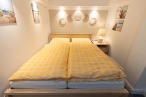 a bedroom with a bed with a yellow comforter at Neue zentrale Souterrain-Wohnung 24h Self Check-In in Hamburg