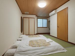 Postel nebo postele na pokoji v ubytování Sakura no Yakata Hotel