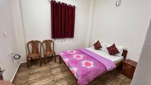 1 Schlafzimmer mit einem Bett mit lila Bettwäsche und 2 Stühlen in der Unterkunft Hotel Pearl Retreat by Nirvaan Hotels in Darjeeling
